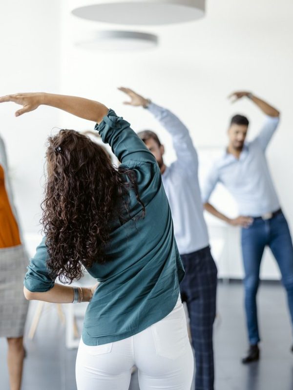 Group Of Multi-ethnic Businesspeople Doing Stretching Exercise At Workplace